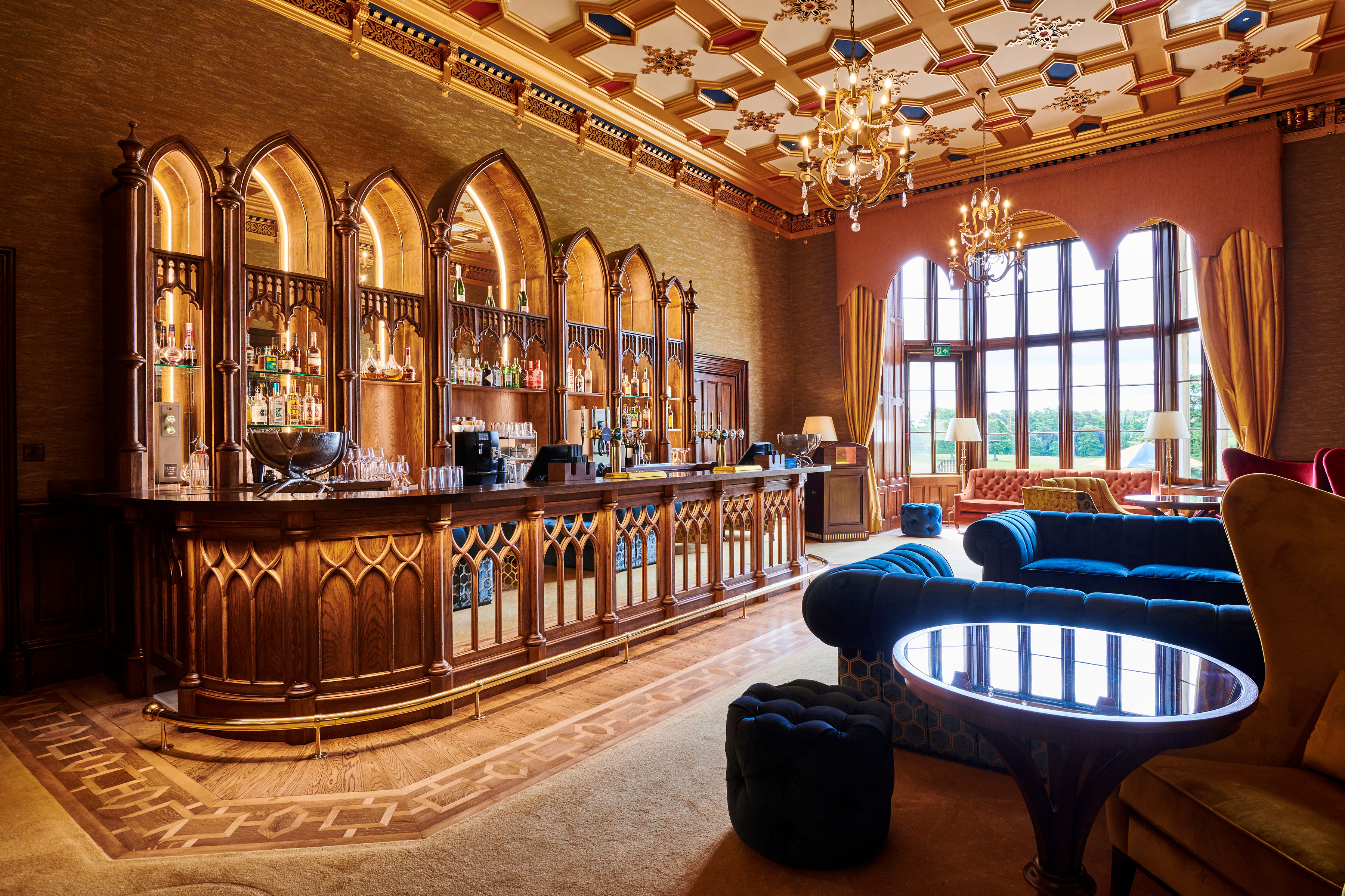 Grand interior of one of the properties. Bar with tables and velvet chairs.