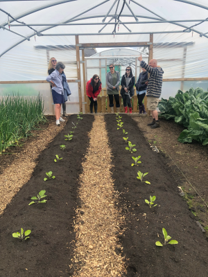 Image of inside a greenhouse with BeaconHouse team at the door.