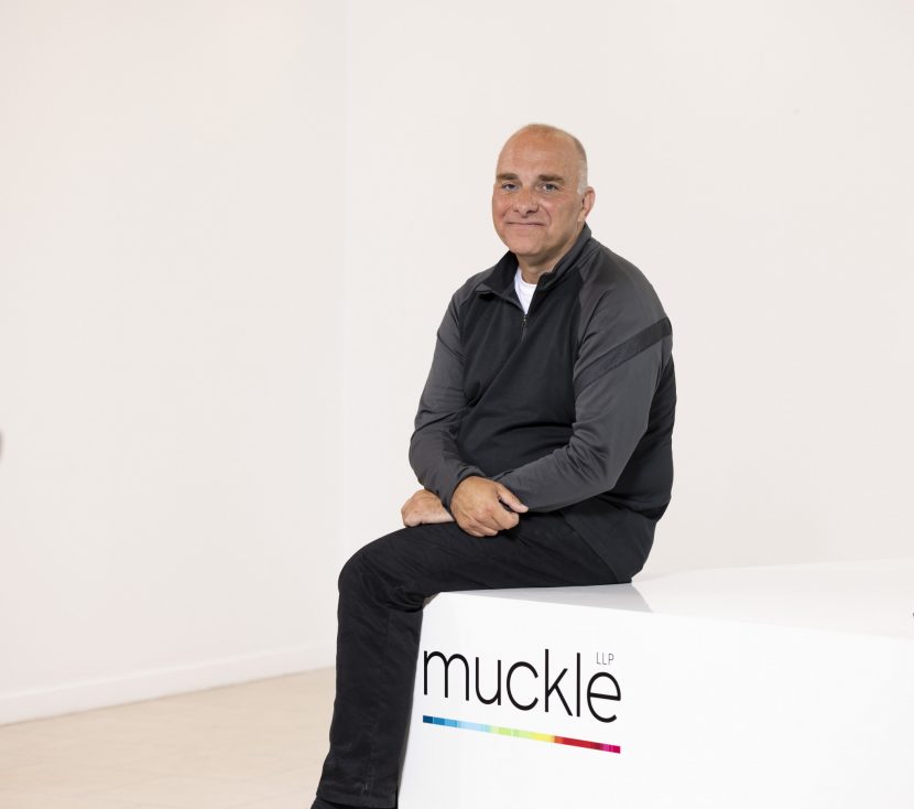 Jason Wainwright sat on Muckle LLP desk for headshot