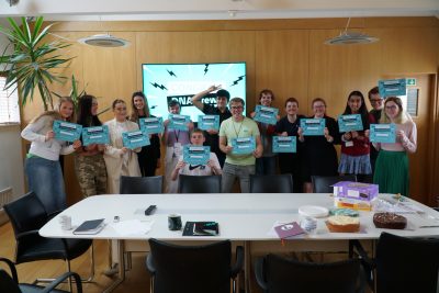 The DNA 2023 graduates smiling and holding their certificates.