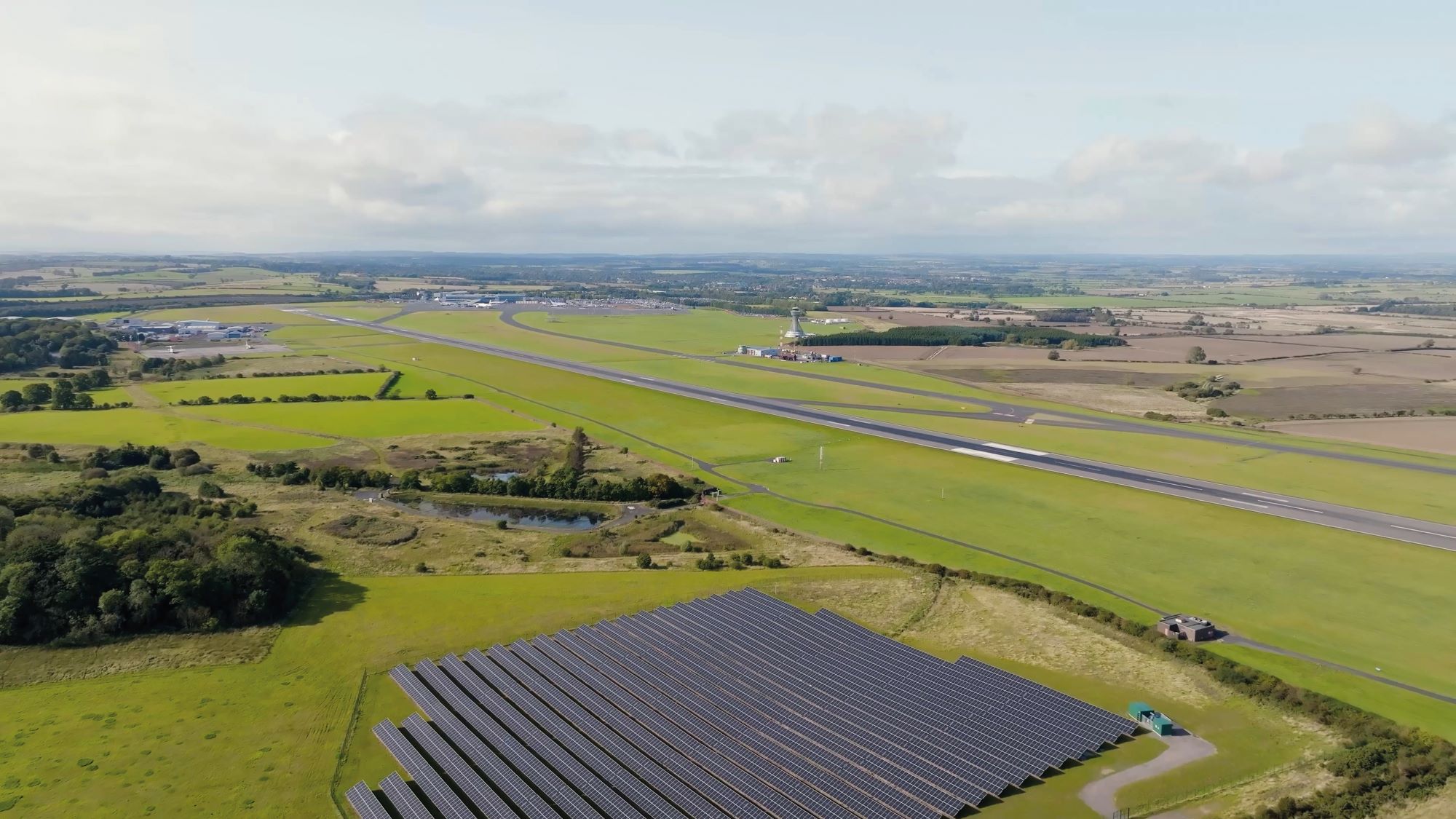 Aerial image of Newcastle Airport runway with large solar farm prominent at the centre bottom of the image.