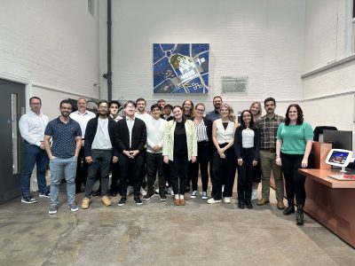 Okana team standing together and smiling to camera in the Ryder Architecture reception area.