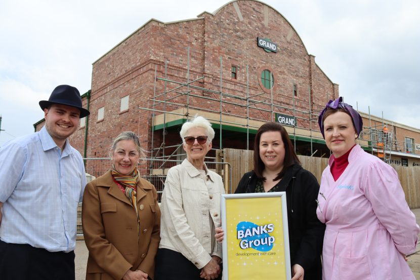 Group image of Beamish Museum and Banks Group reps standing outside Beamish Museum cinema and two people are holding a plaque.