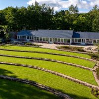 Aerial image of Raby Castle garden with long sun-room style building at the back of the garden.