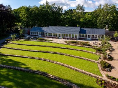 Aerial image of Raby Castle garden with long sun-room style building at the back of the garden.