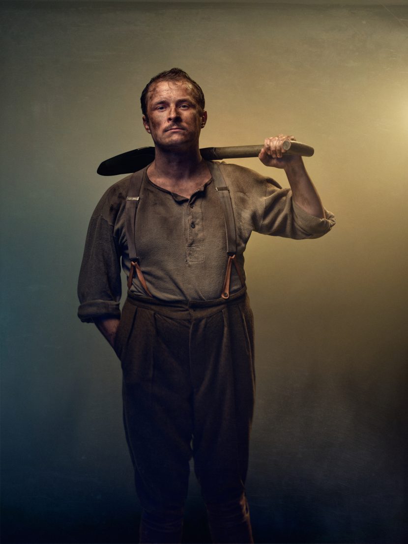 Actor from Birdsong play holding shovel and in First World War style clothing.