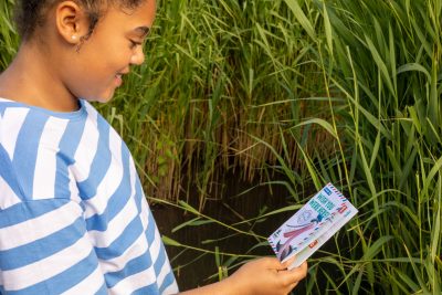 A young girl looking at her adventure trail book