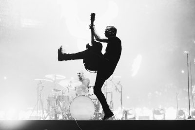 Bryan Adams performing on stage with a guitar