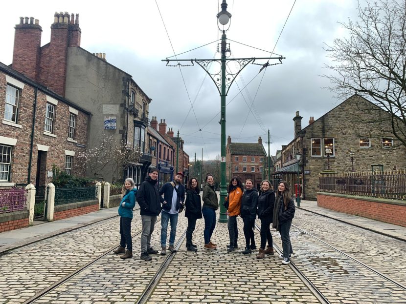 Group of people in a row in the middle of a street at Beamish Museum.