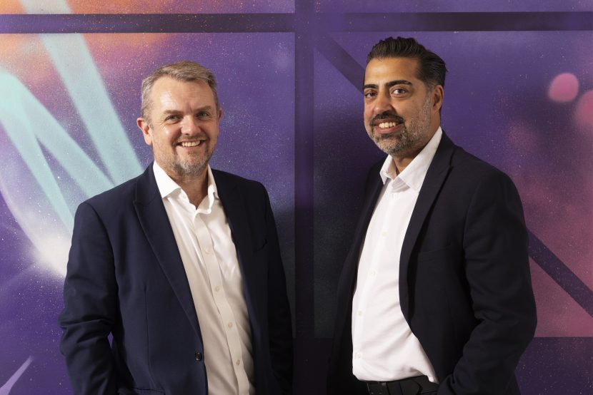 Two UNW team members posing for camera in their offices.