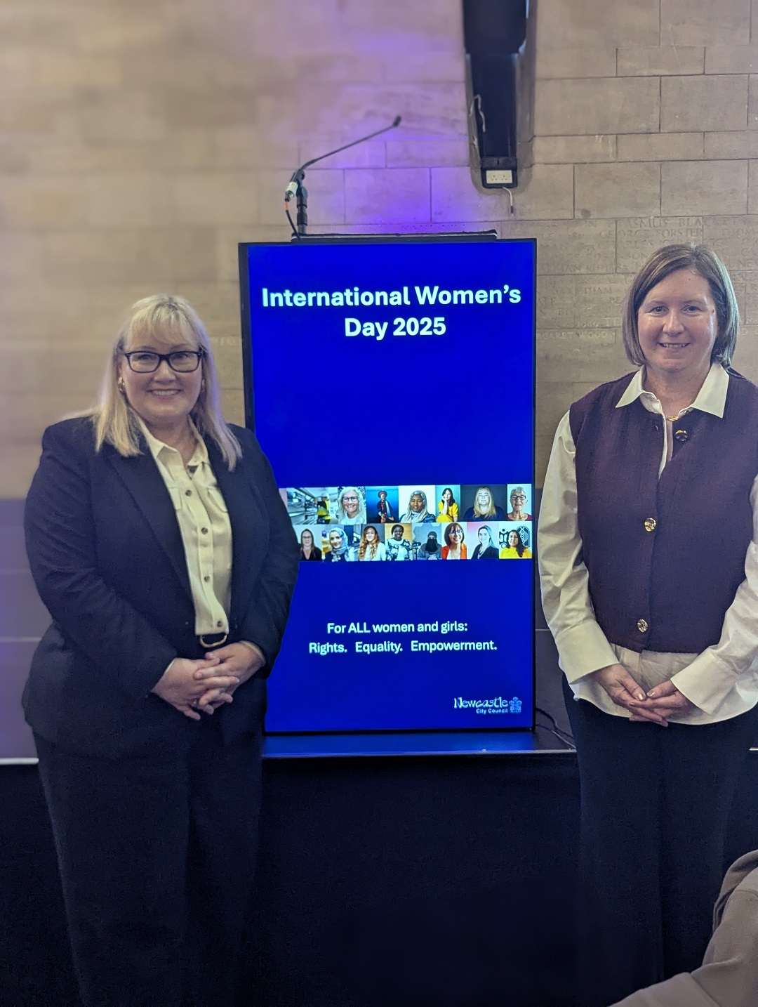 Cllr Karen Kilgour and Pam Smith stood either side of a screen which is displaying a graphic which reads International Women's Day 2025